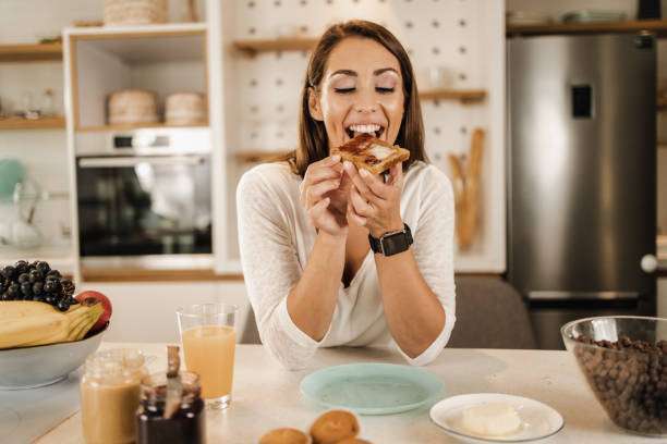young smiling woman having breakfast, toaster