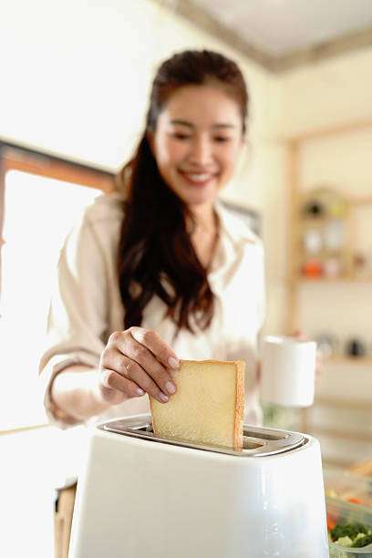 smiling woman preparing toaster for breakfast