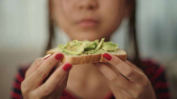Close-up asian teenage girl eating avocado toast.Toaster