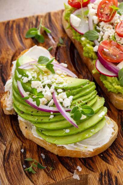 Two avocado toasts garnished with tomatoes, radishes, Toaster