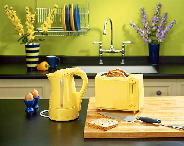 Bright yellow kitchen with a working toaster and a kettle on the counter.