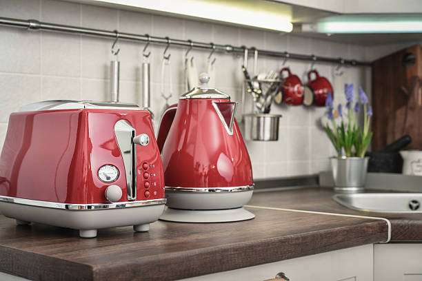 Red toaster and kettle on kitchen counter.