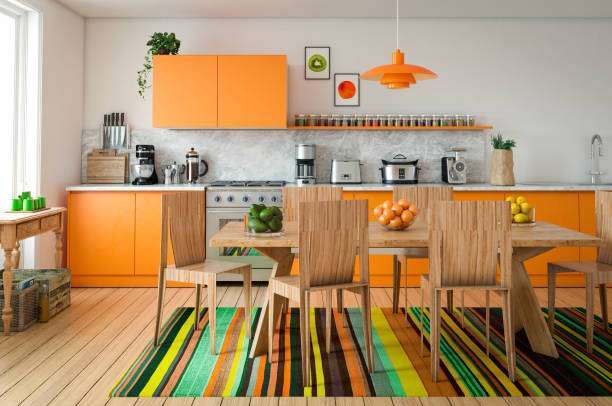 Bright orange kitchen cabinets with a dining table, ideal for making toaster breakfasts.
