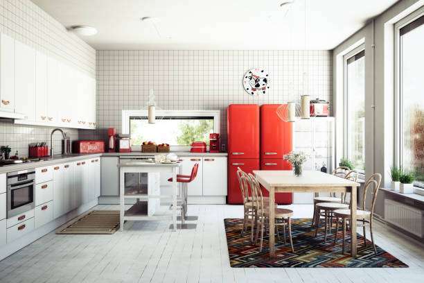 Retro white and red kitchen with a small red toaster, large fridge, and dining table.