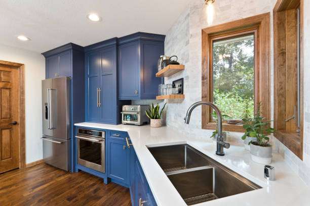 Stylish blue kitchen features a compact toaster oven on the pristine white countertop.