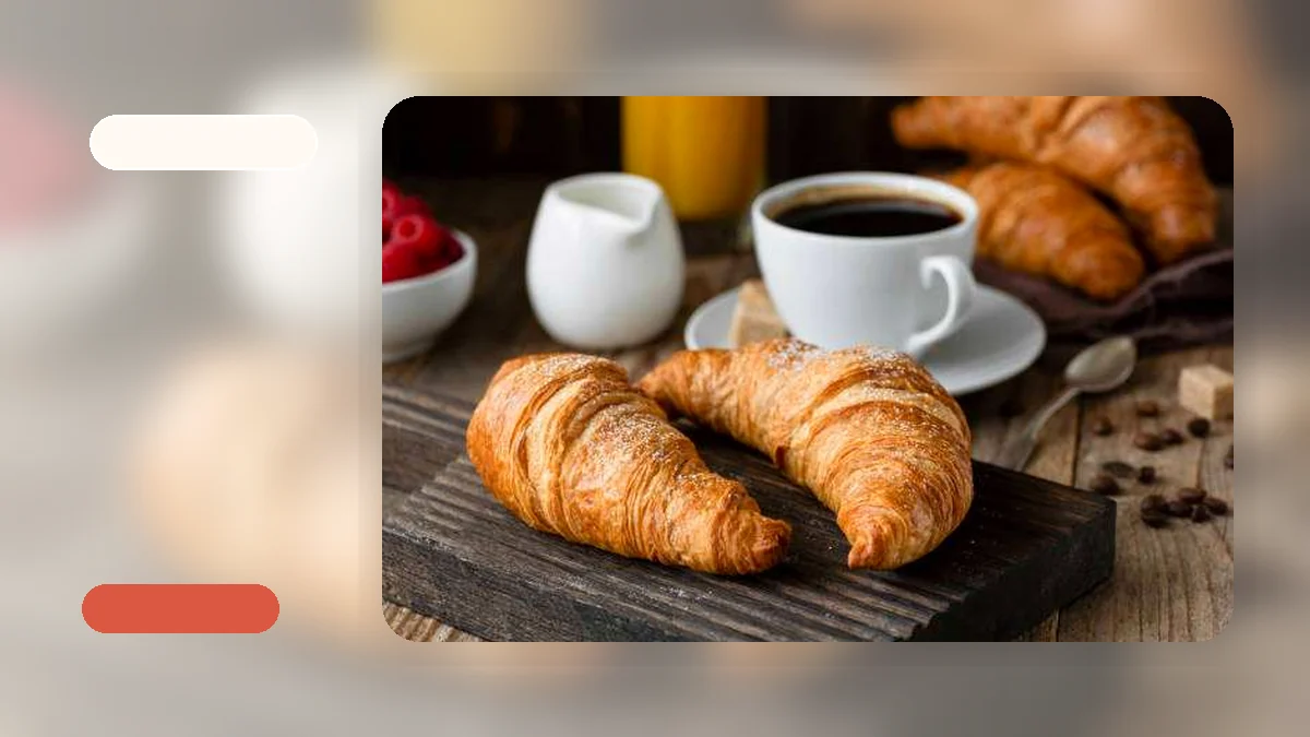 A wide-slot toaster with a croissant half resting on its warming rack